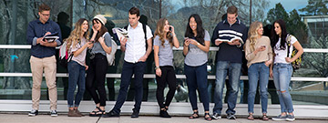 Group of students reading, sharing music, and talking