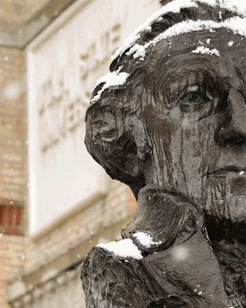 A photo of a snow covered George Washington bust just outside of Old Main at Utah State University.