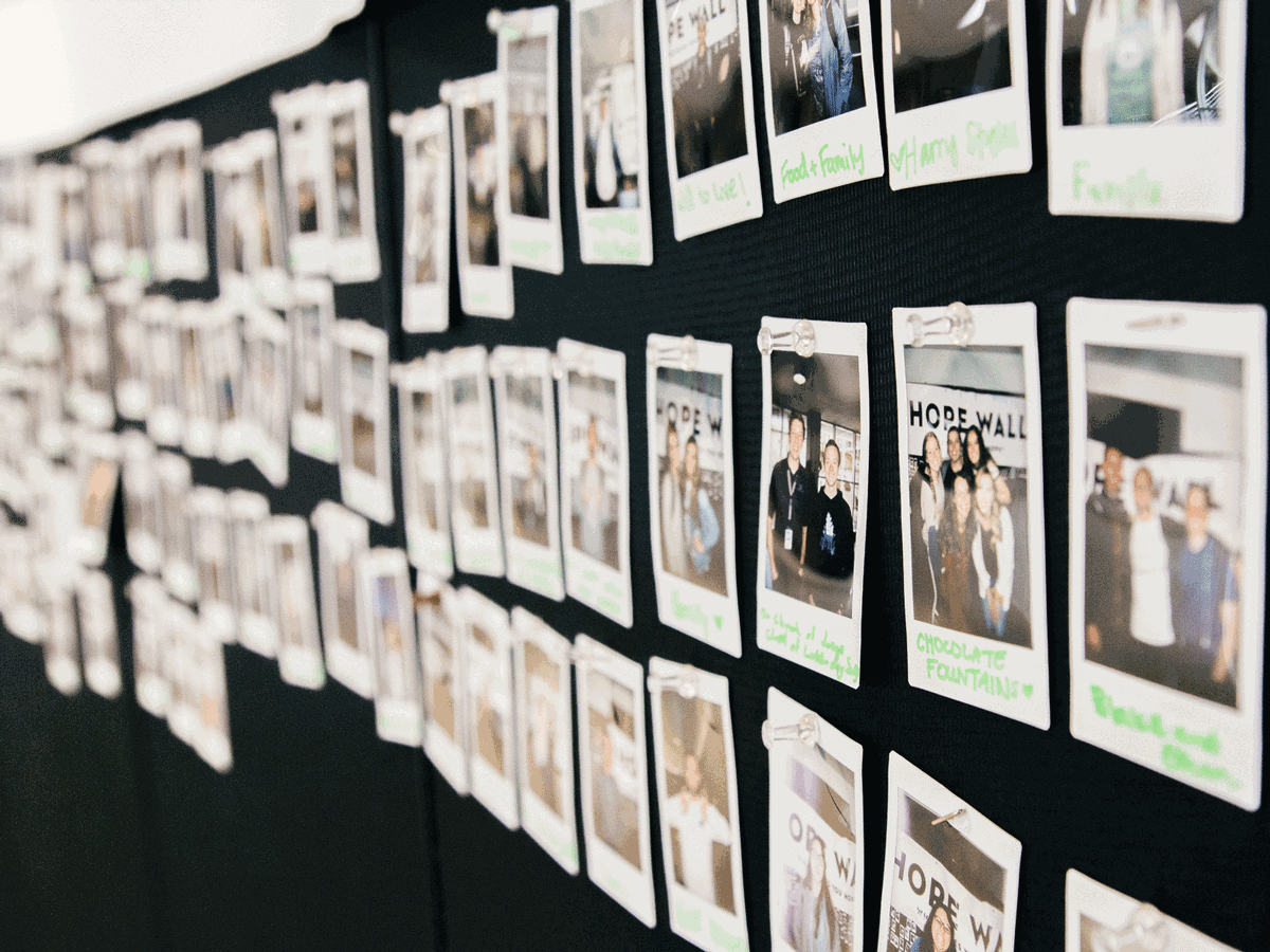Polaroid pictures of students who have written what gives them hope on a bulletin board.