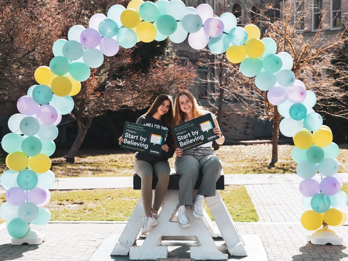 Two students pose for a photo on top of the block A