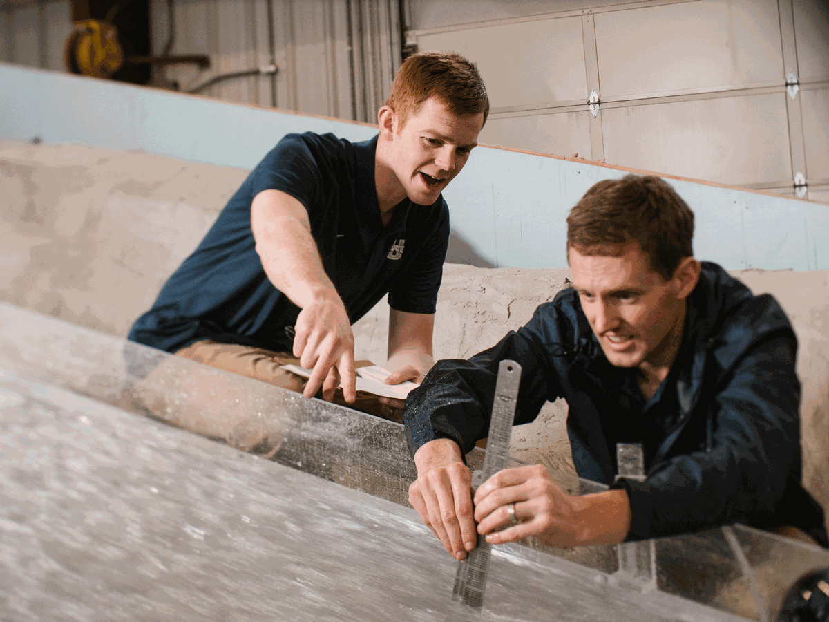 Students measuring water flow at USU's Splash Lab.