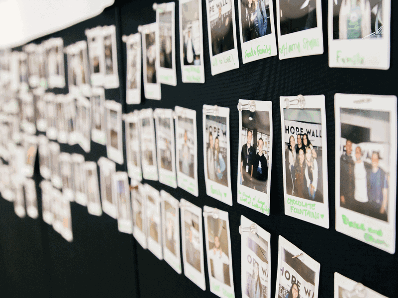 Polaroid pictures of students who have written what gives them hope on a bulletin board.