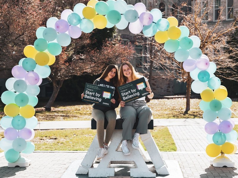 Two students pose for a photo on top of the block A