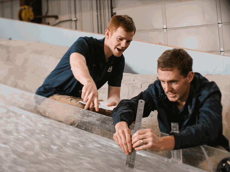 Students measuring water flow at USU's Splash Lab.