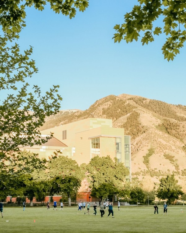 Students walk across the grass on the quad during a summer afternoon