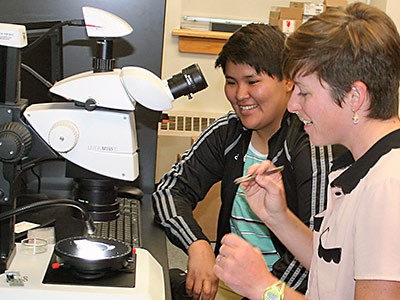 Professor and student use microscope