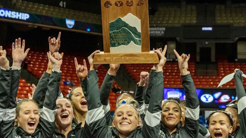 USU gymnasts lift the Mountain Rim Gymnastics Conference trophy on March 19 in Boise.