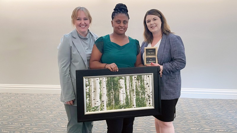 Three women at an awards ceremony.