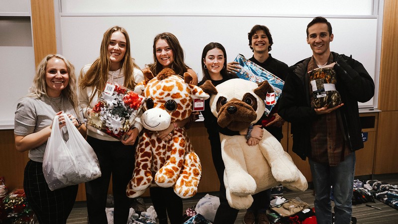 Students holding Christmas presents.