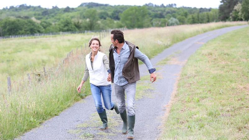 A couple running down a rural path.