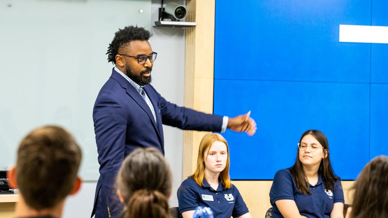 Isaiah Jones speaks to others in a conference room.