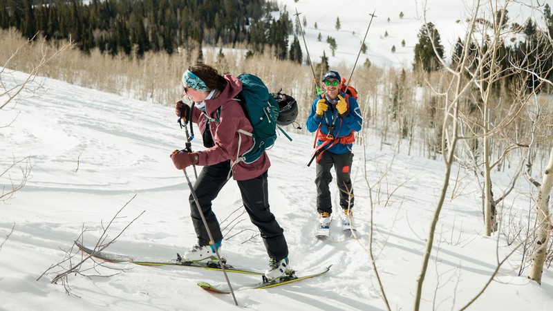 Two backcountry skiers climbing a snowy hill.