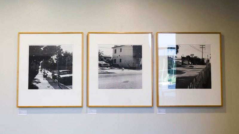 Three photographs hanging in an exhibit.