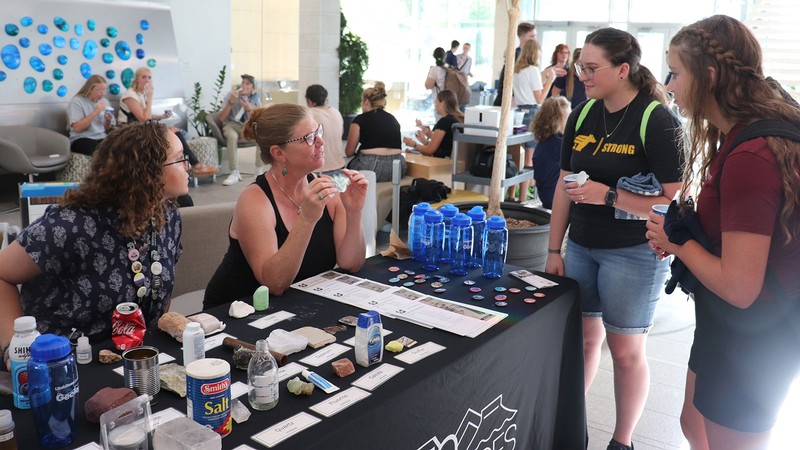 People speak at an event booth.