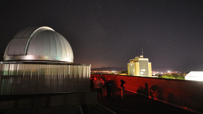 People look up outside the USU Observatory's dome.