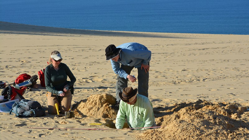 Geoscientists collecting samples on a beach.