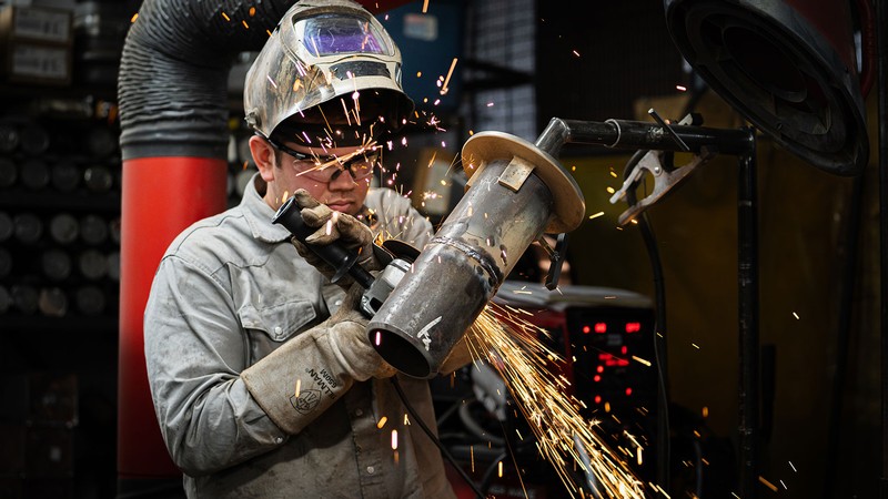 Sparks flying as a welder uses a grinder.