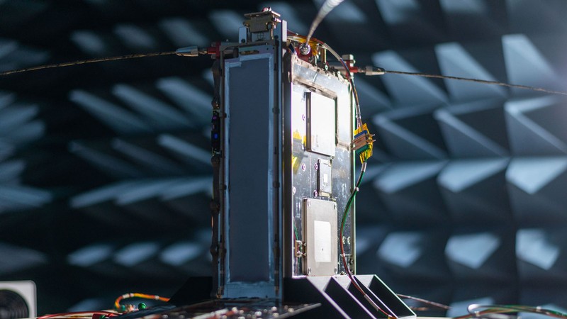 A small electronic satellite is tested in a specialized chamber at Space Dynamics Lab.