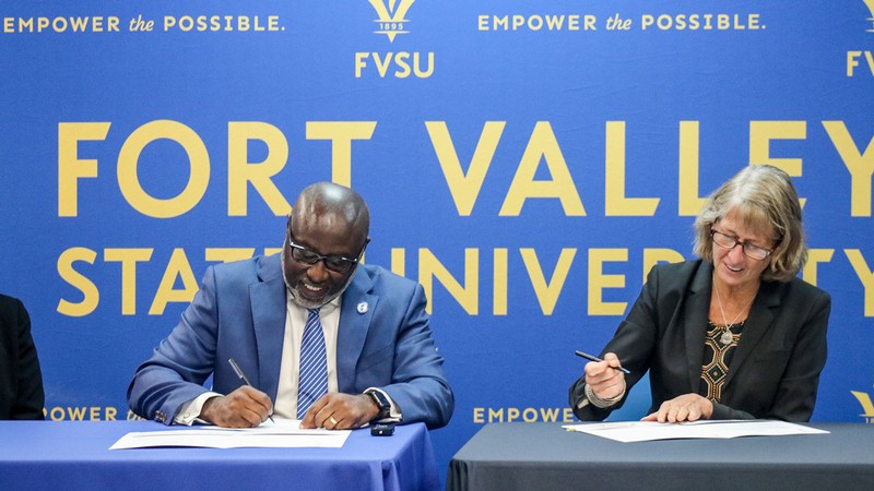 University presidents signing a document.