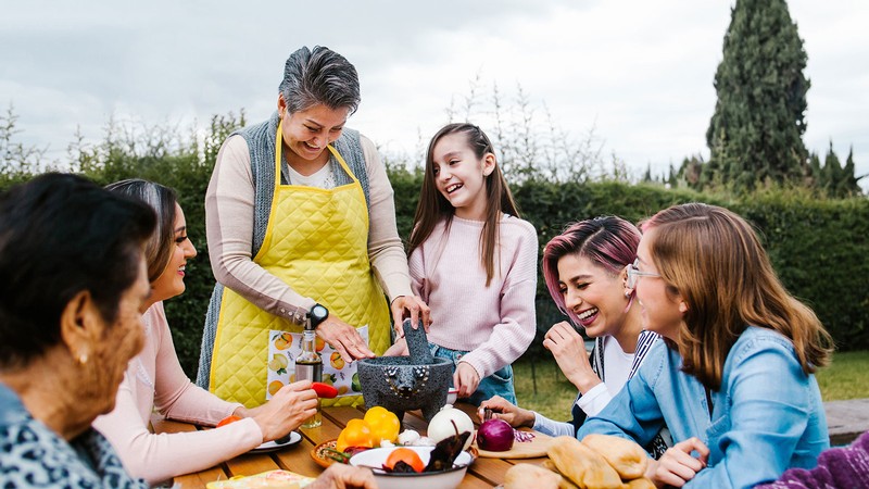 Women sit around a picnic table for a meal.