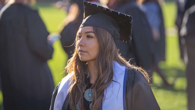 A woman wearing graduation robes.