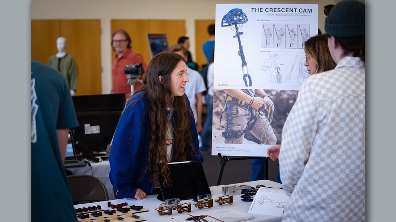 Baylee Volger explaining a rock climbing device she designed.