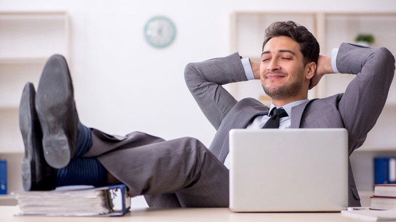 A worker reclining at a desk.