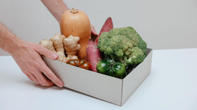 A pair of hands holding vegetables.
