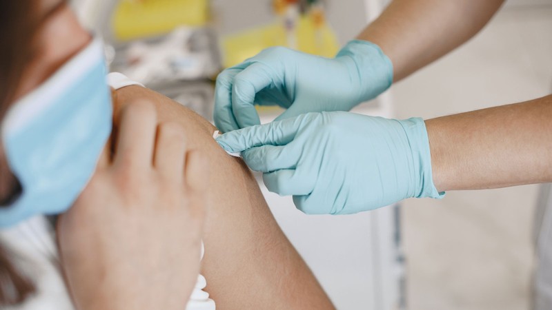A health care worker prepping a patient for a vaccine.