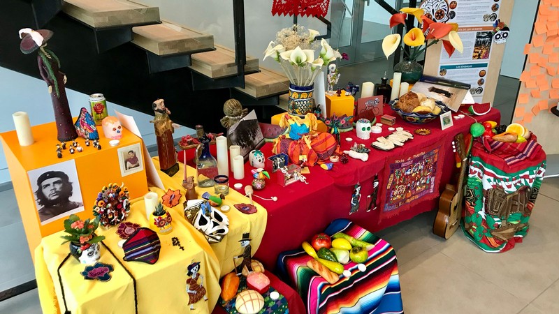 A table with flowers and other Mexican heritage items.