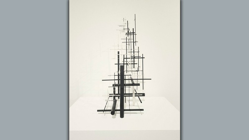 A sculpture of several black and white steel rods intersecting at right angles.