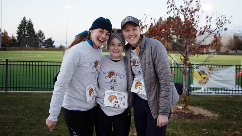 Three students pose for a photo before a race