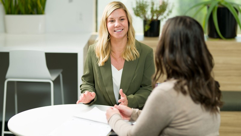 Two people talking at a table.