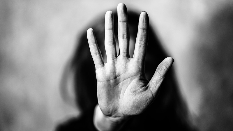 A woman holding a hand in front of her face.