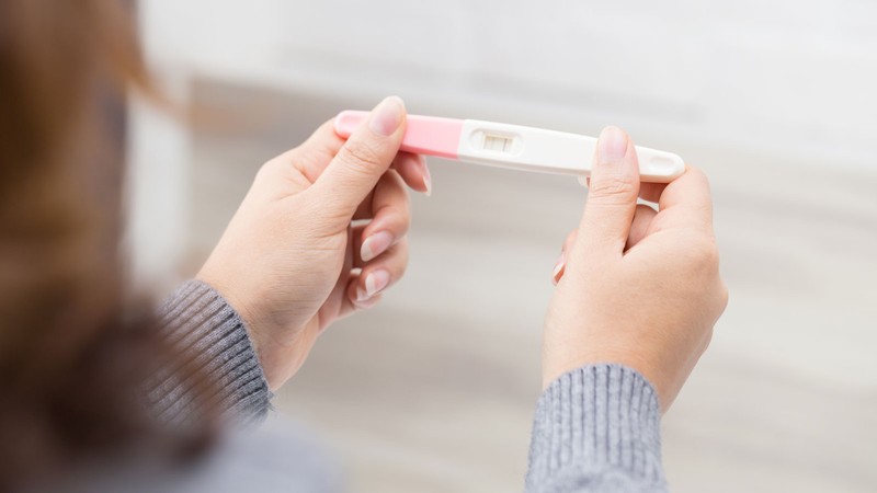A person looking at a pregnancy test.
