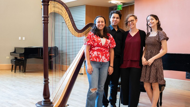 People standing by a harp.