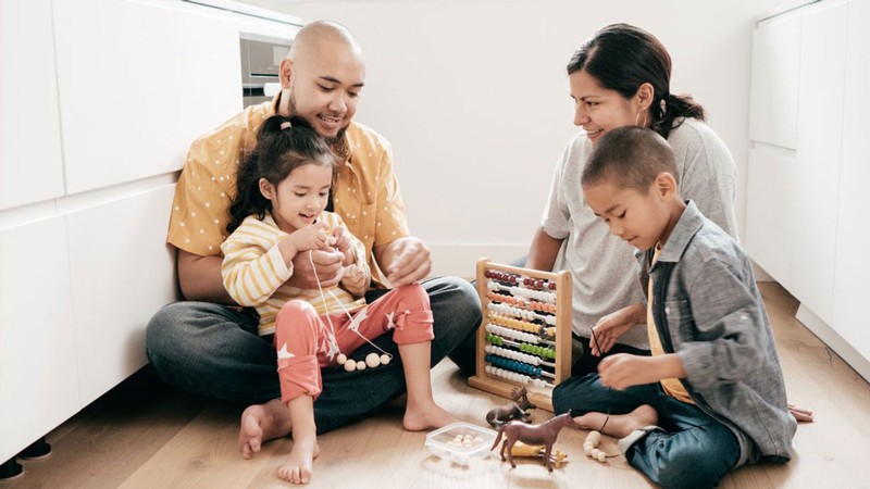 A family playing in a kitchen.