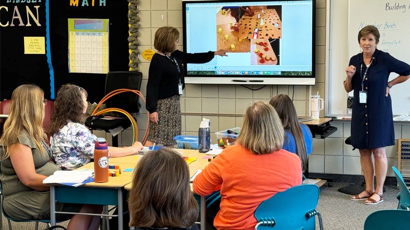 Educators teaching each other in a classroom.