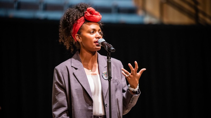 Cree Taylor speaking at a microphone.