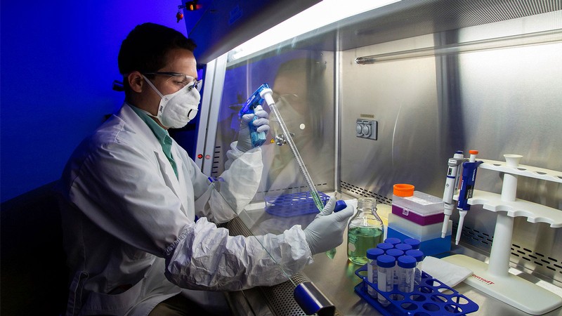 A student wearing protective equipment works in a lab.