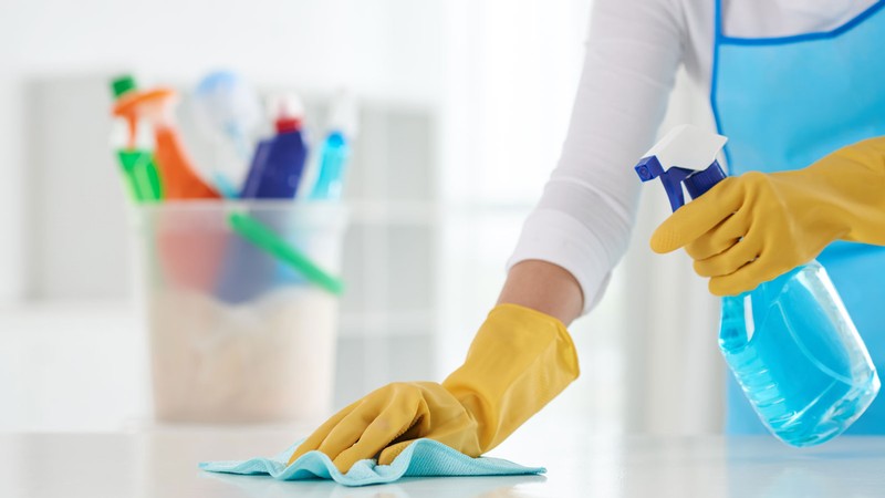 A person cleaning a table.