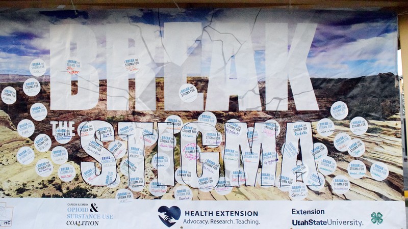 A poster with stickers bearing individual names and the words "I break the stigma for."