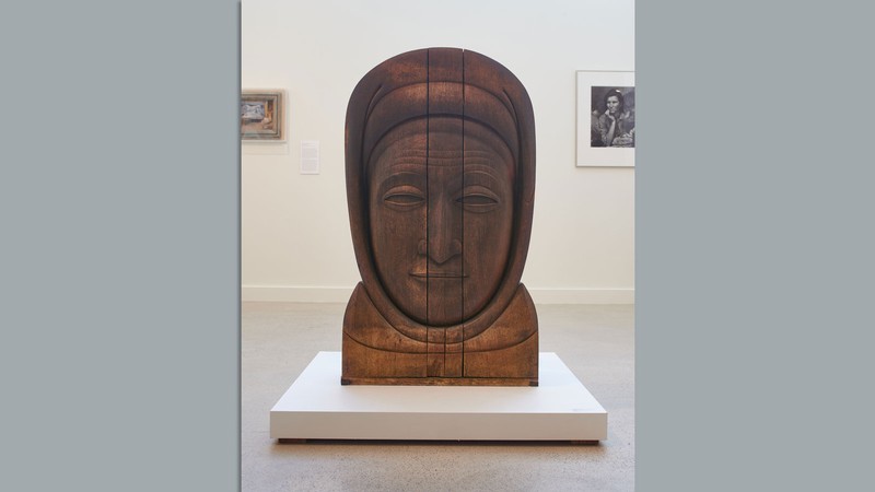 A large wooden sculpture of a woman's face.