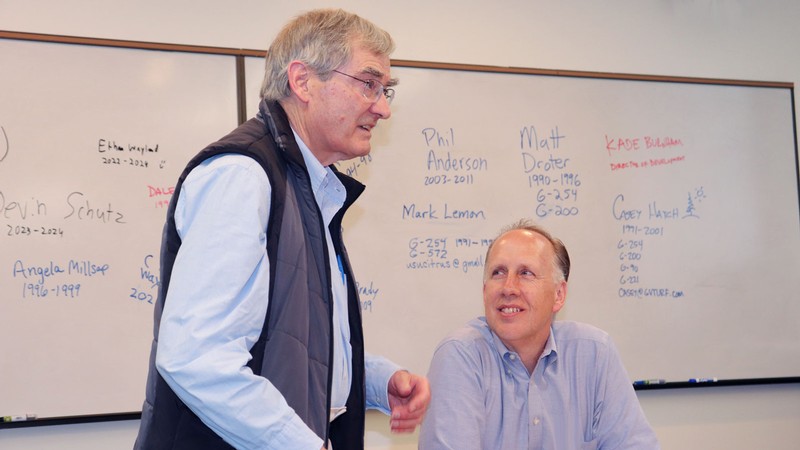 Two speakers at a whiteboard.