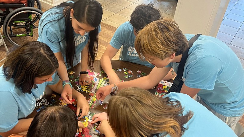 Students working together on a jigsaw puzzle.