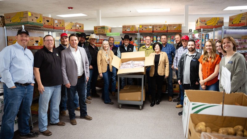 People posing for a group photo in a food pantry.