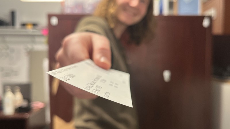 A person handing you a concert ticket.