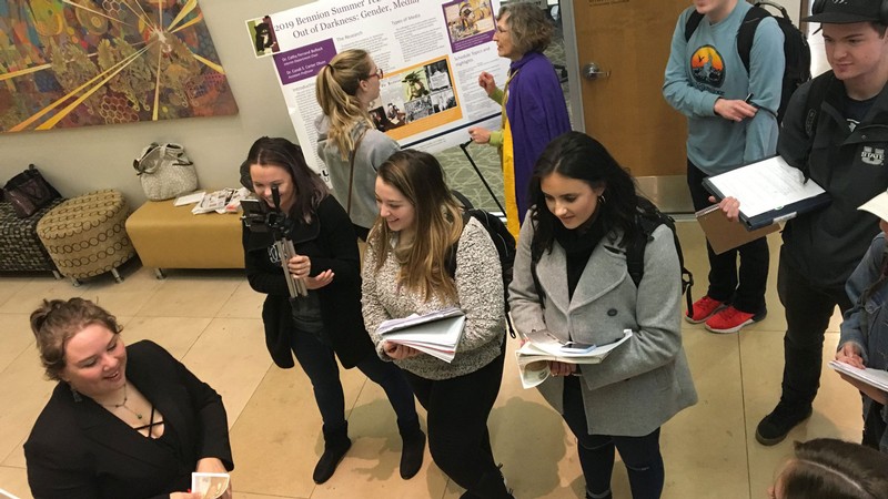 Students and faculty talking about research posters.