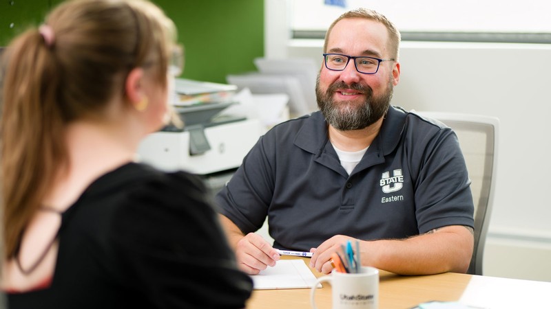 Jeff Spears speaking with a student in his office.