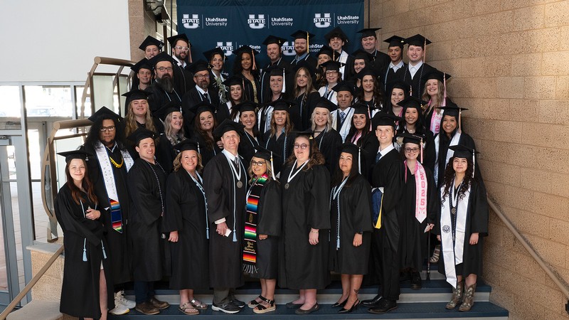 Graduates pose for a photo on a staircase.